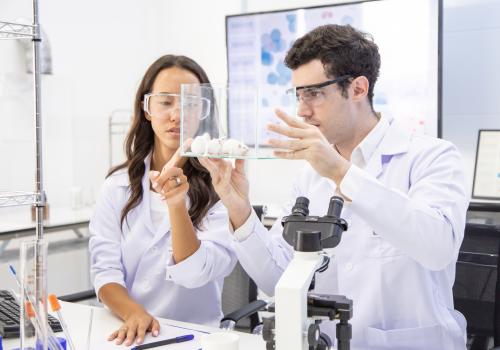 People in lab coats looking at mice