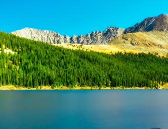 Picture of woods and lake with hills in the background