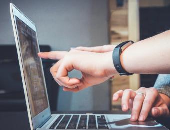 Person pointing their finger at a computer screen