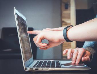 person pointing at laptop screen