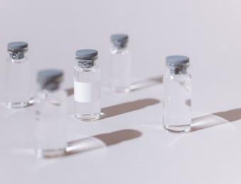 Five vaccination vials on a grey background